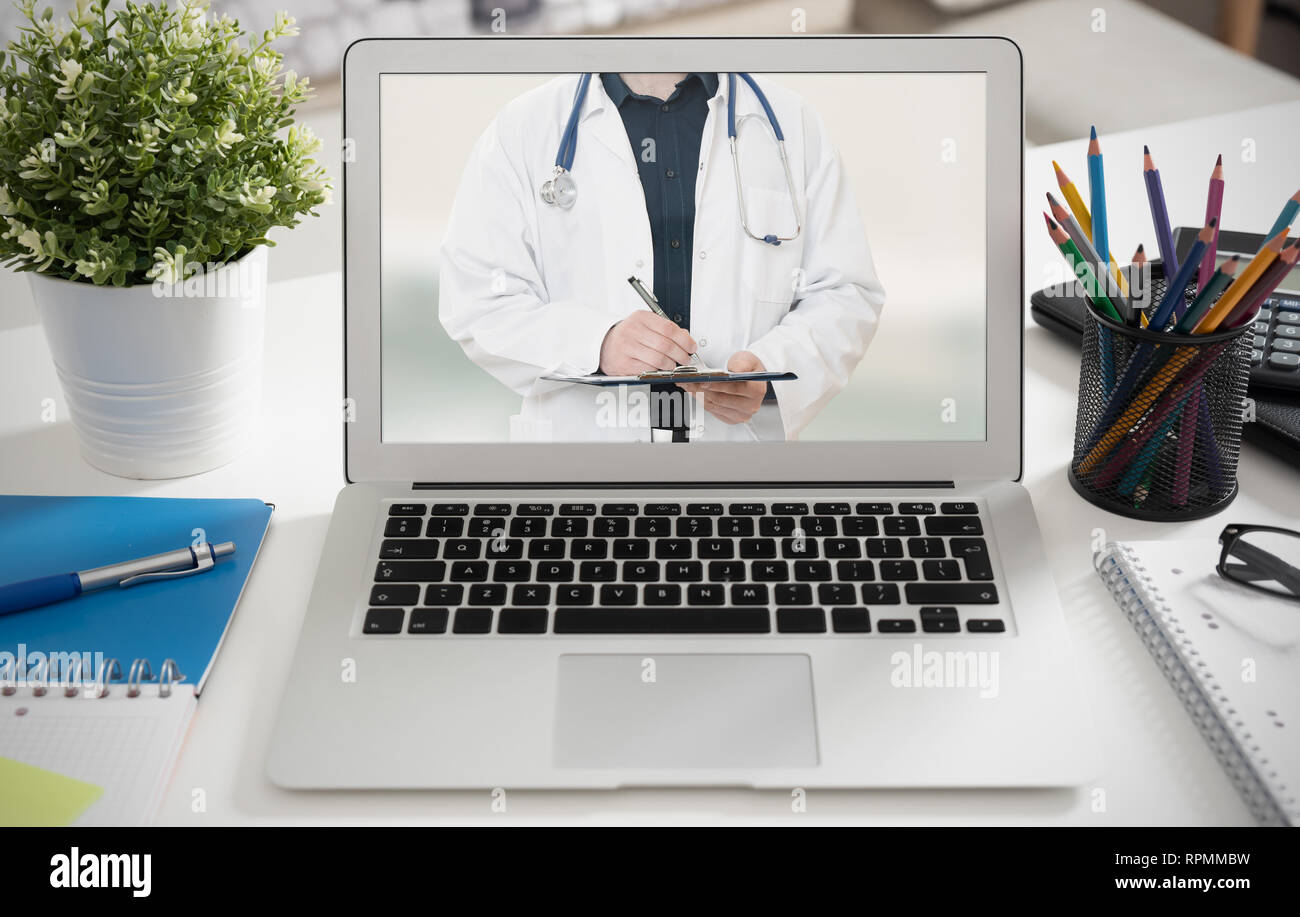 Medico con uno stetoscopio sul computer allo schermo del laptop. La telemedicina o la telesanità concetto. Foto Stock