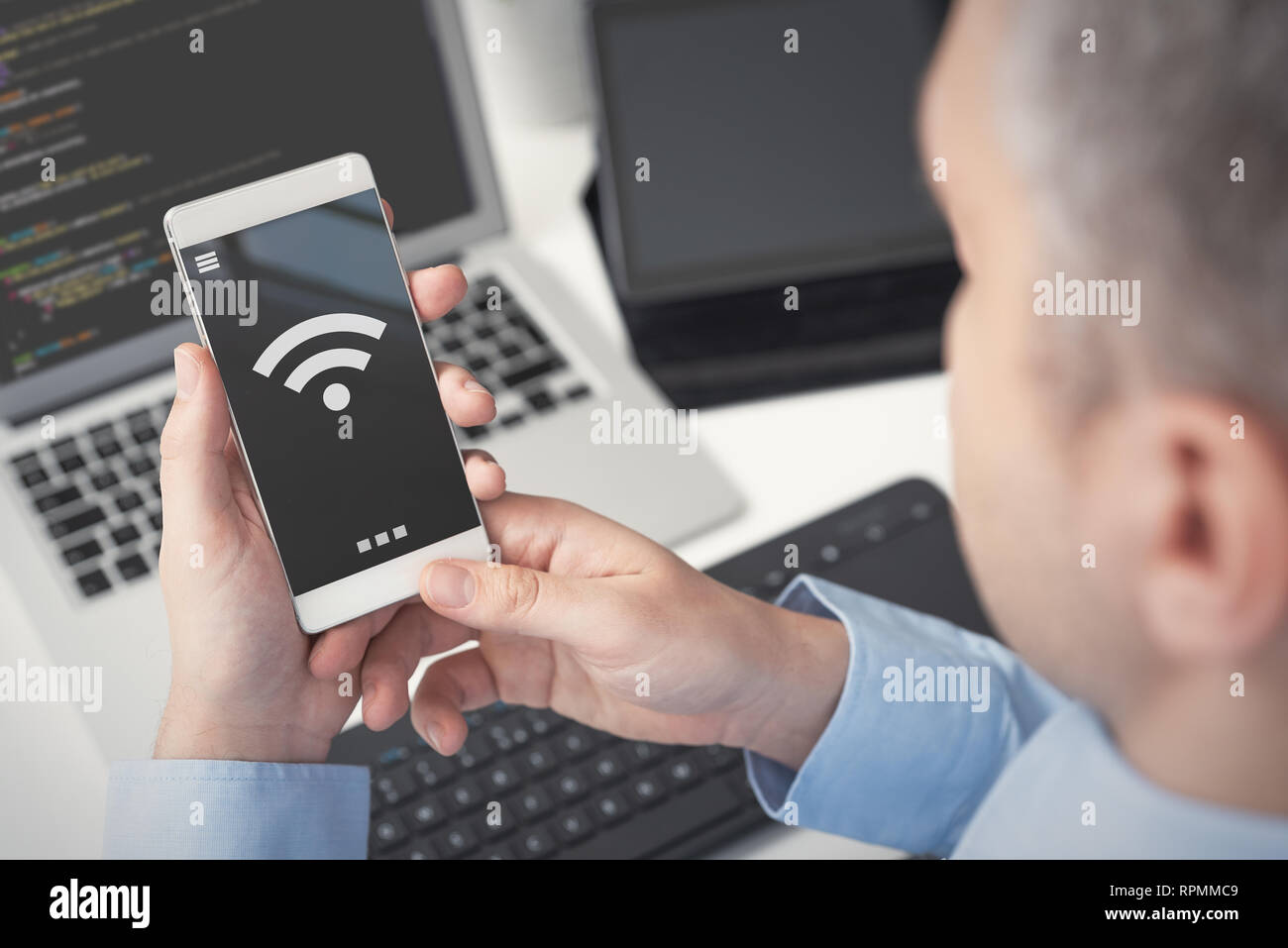 Uomo che utilizza smartphone con simbolo wireless. Mobile internet concept Foto Stock