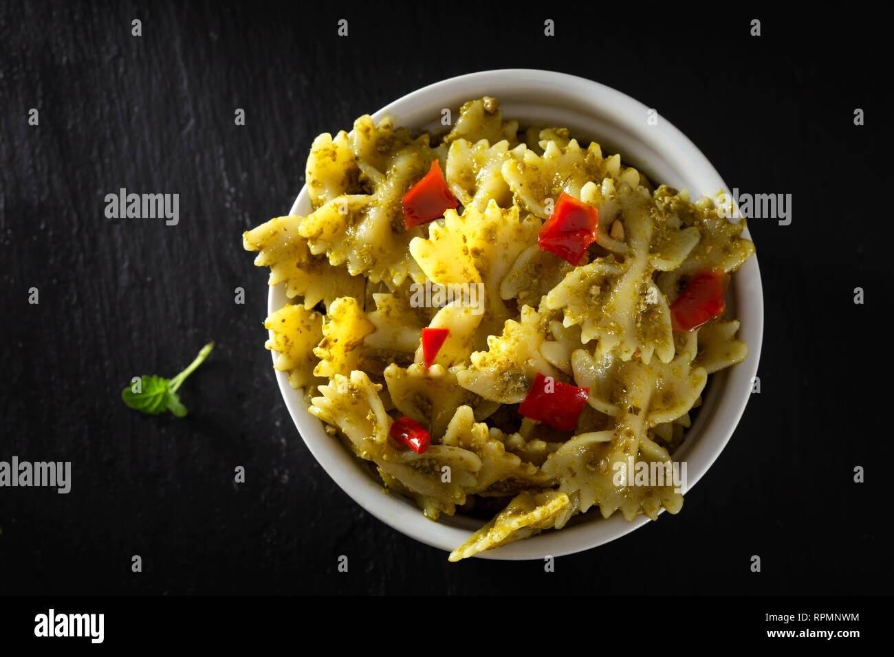 Farfalle di pasta con il pesto e pezzi di red hot pepper - vista superiore Foto Stock