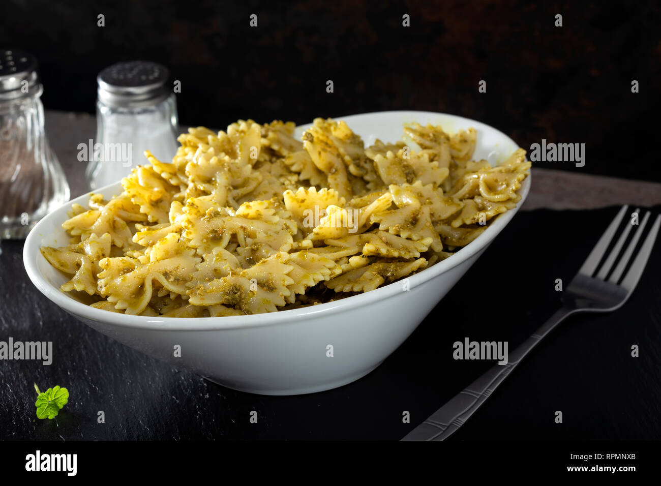 Farfalle di pasta con il pesto in una ciotola bianco Foto Stock