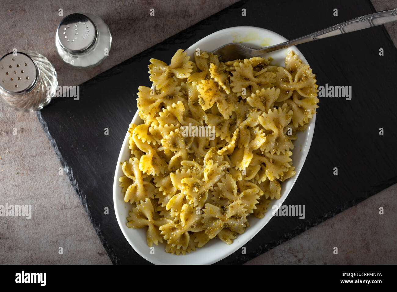 Farfalle di pasta con il pesto in una ciotola bianco - vista superiore Foto Stock