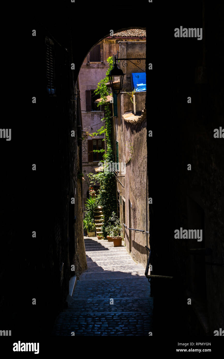 Il percorso stretto, andando verso il basso tra le case di Tivoli, Italia Foto Stock