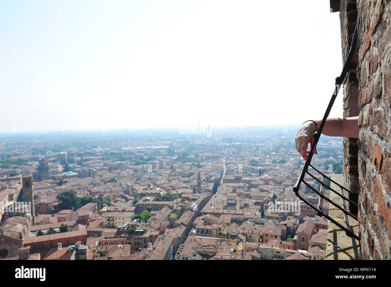 Dettaglio di un uomo del braccio appoggiato su una delle finestre sulla sommità della torre degli Asinelli a Bologna, Italia Foto Stock