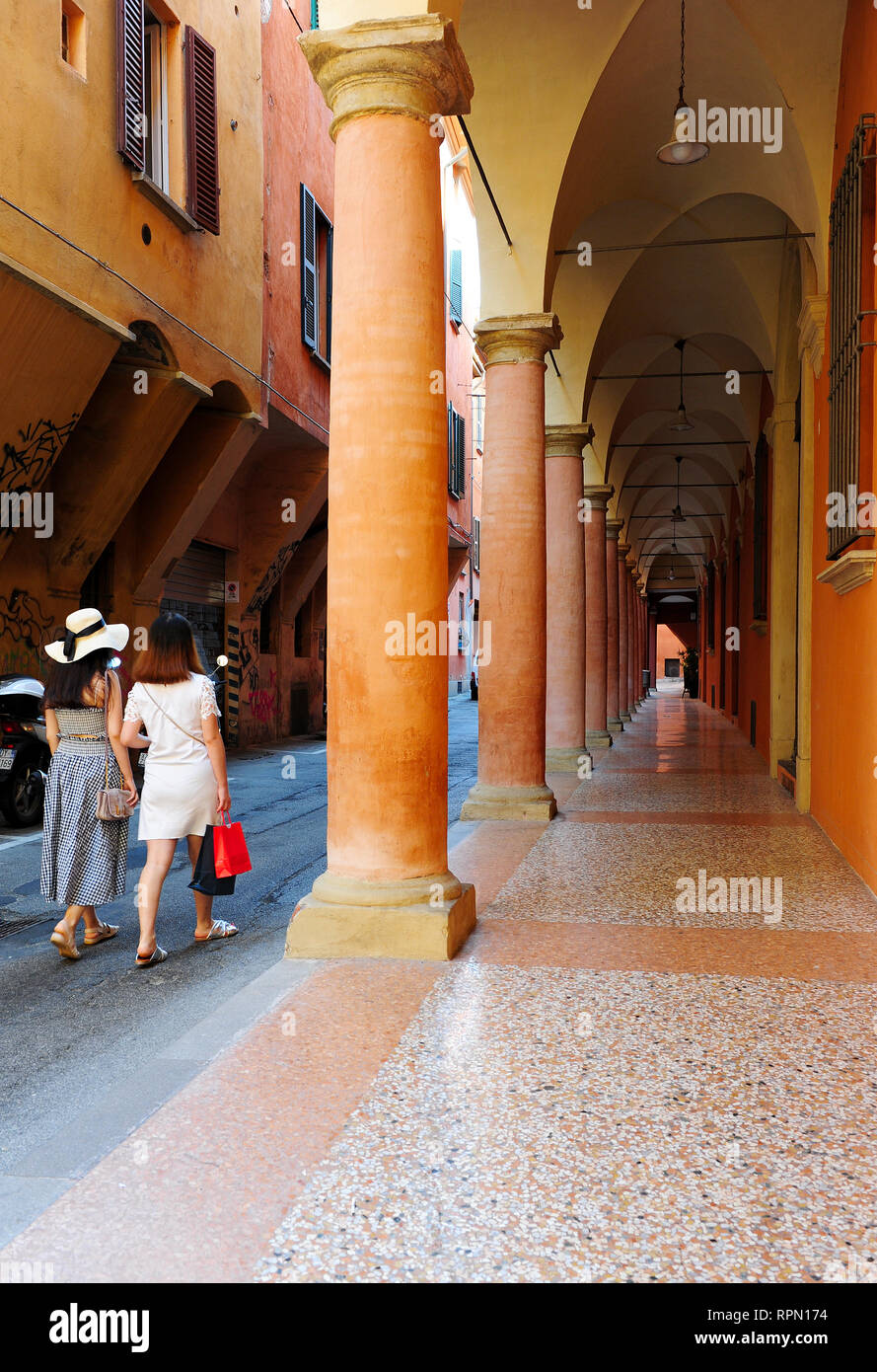 Ragazze che camminano per i portici nel centro di Bologna, Italia. I portici di Bologna sono stati patrimonio dell'umanità dell'UNESCO dal 2021 Foto Stock