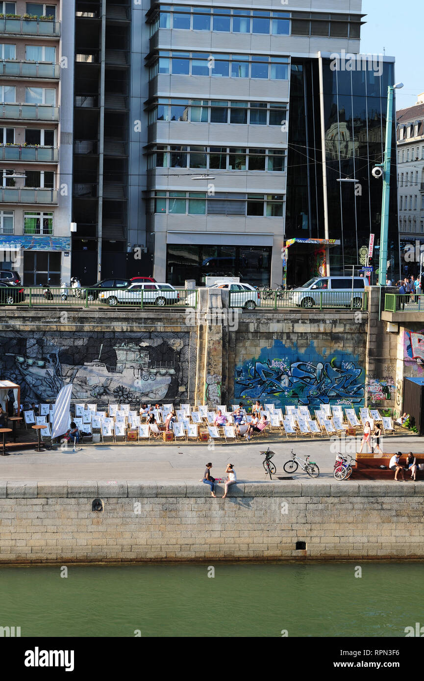 La gente la refrigerazione lungo il canale del Danubio (Donaukanal) nel centro di Vienna, Austria Foto Stock