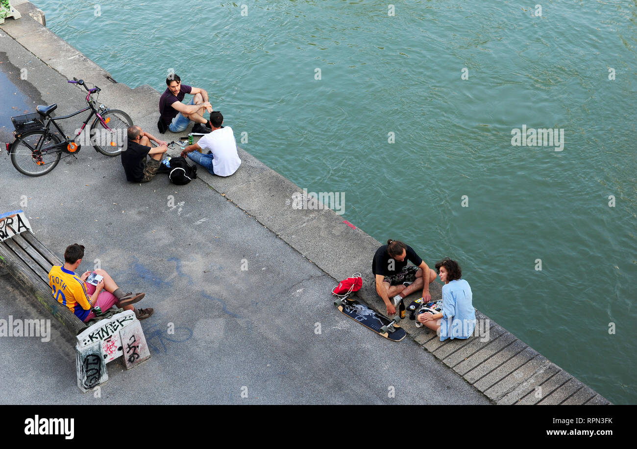 I giovani la refrigerazione lungo il canale del Danubio (Donaukanal) in estate, Vienna, Austria Foto Stock