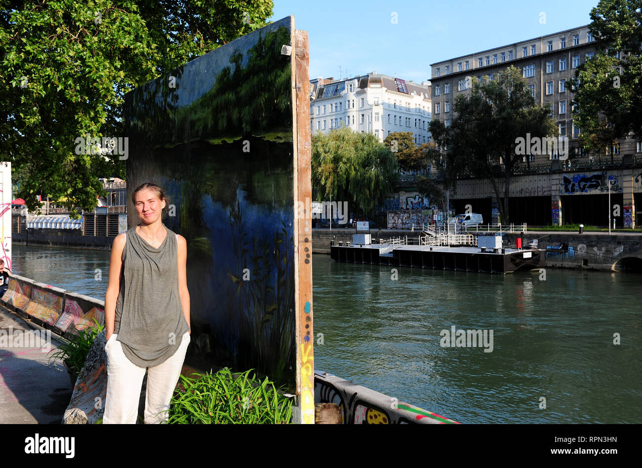Artista ucraino Anja Filatova pone accanto a una delle sue opere lungo il Donaukanal, Vienna, Austria Foto Stock