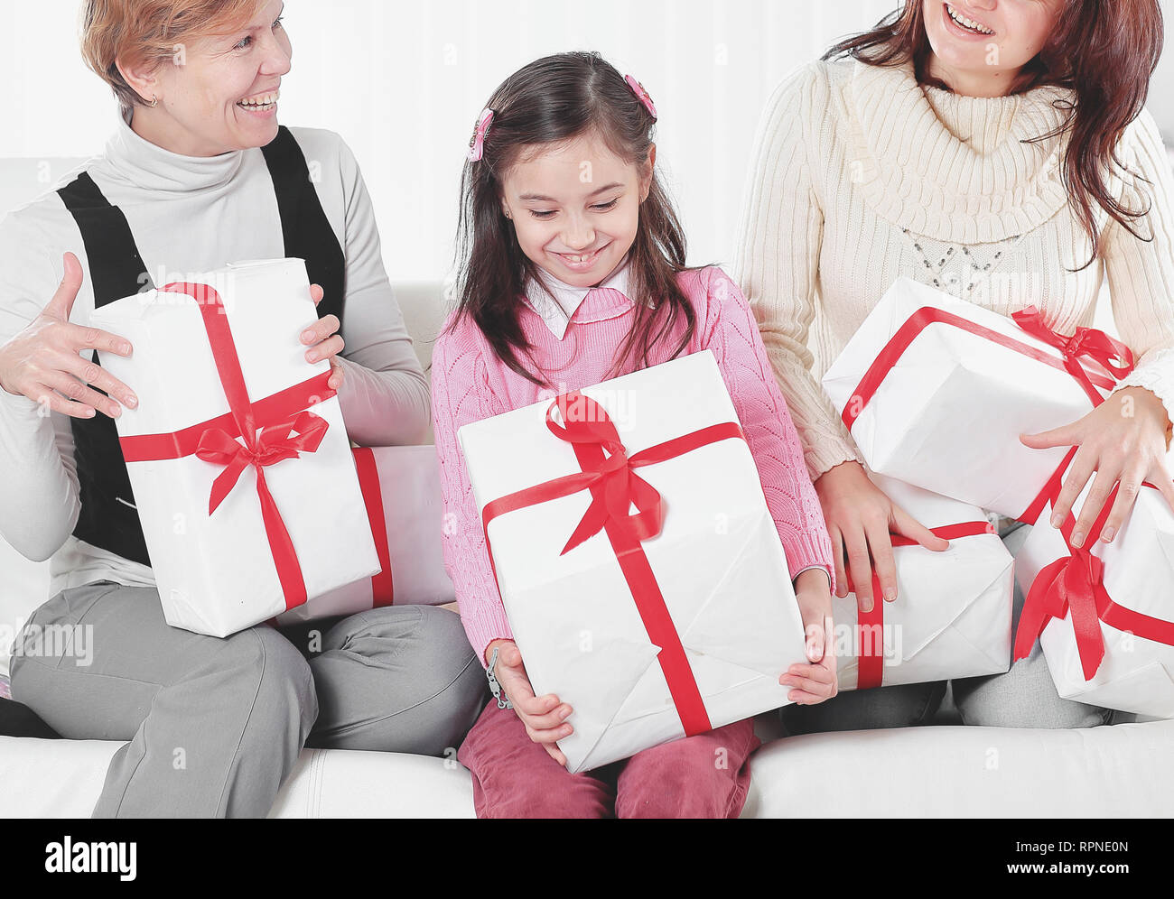 Nonna, madre e figlia con confezioni regalo seduta sul divano.Concetto di vacanza Foto Stock