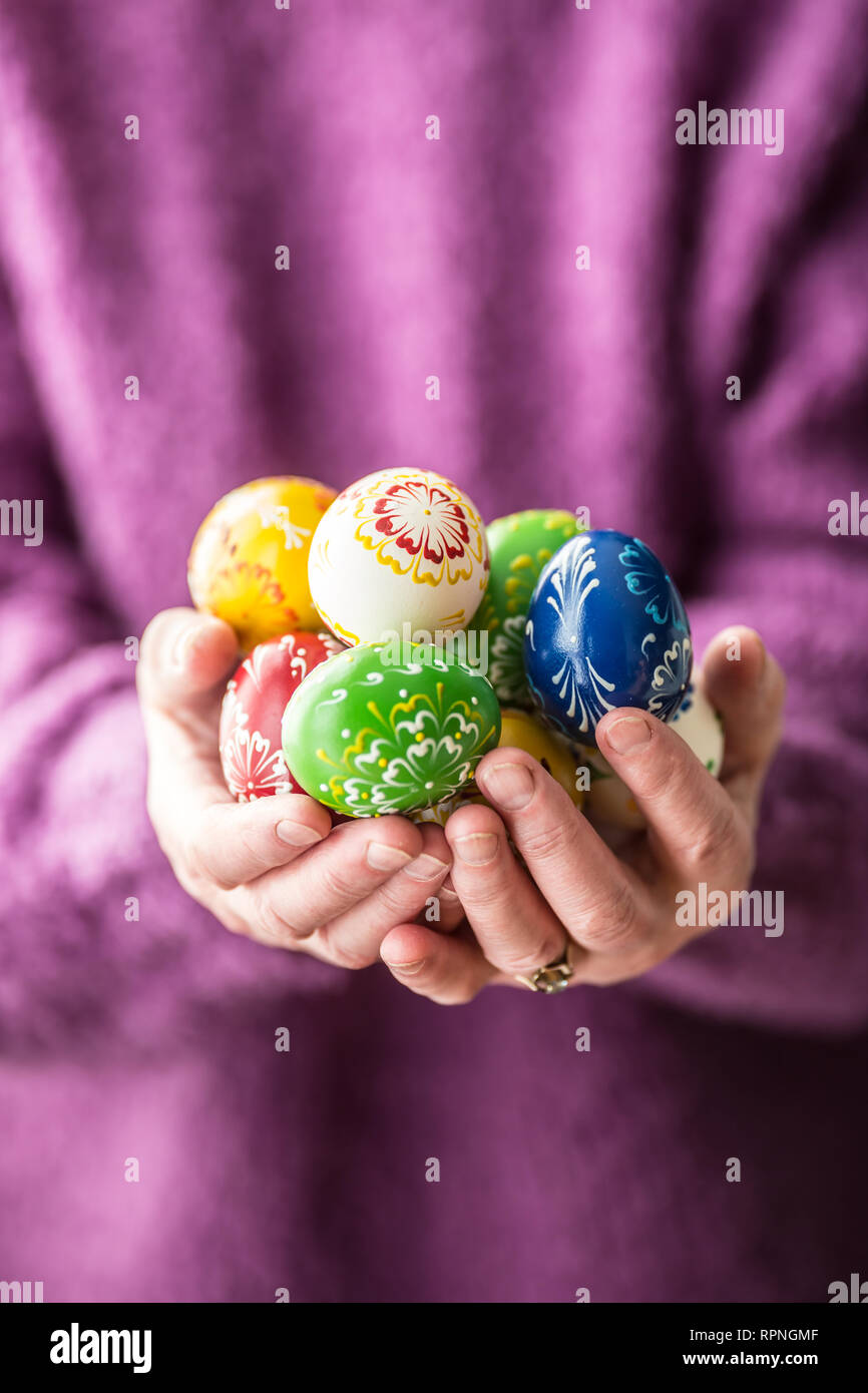 Close-up multicolore di uova di pasqua nel senior donna mani. Foto Stock