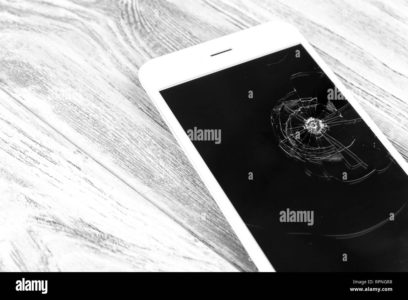 Smartphone con schermo rotto sul tavolo di legno. Foto Stock