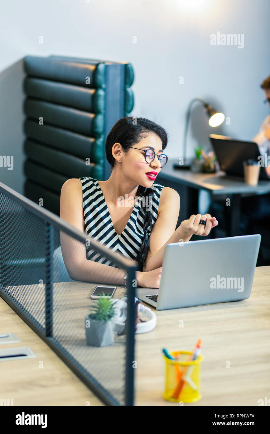 Affascinante femmina longhaired persona appoggiata sul tavolo Foto Stock