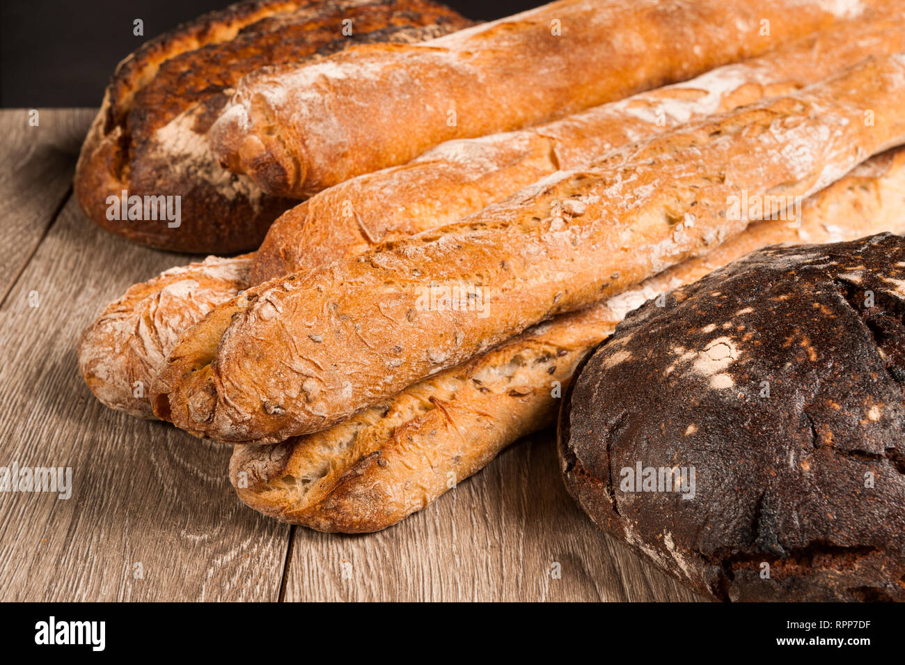 Cereali e baguette fig pane con prugne su sfondo scuro Foto Stock