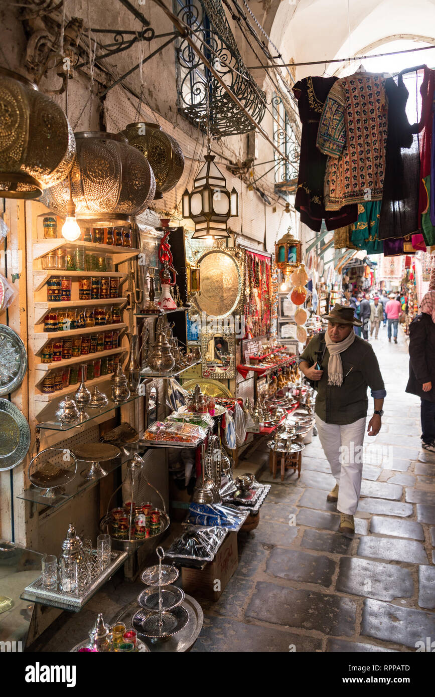 Tunisi, Tunisia - Aprile 3: Escursionisti cammina davanti a un negozio che vende souvenir in un mercato nella medina di Tunisi, Tunisia il 3 aprile 2018 Foto Stock