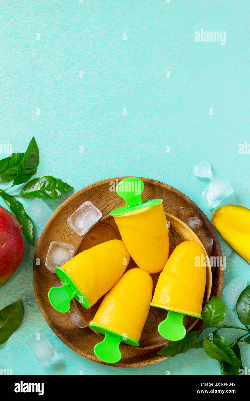 Vegano sano di mango orange citrus gelato ghiaccioli. Estate dessert. Vista superiore piatta sullo sfondo dei laici. Copia dello spazio. Foto Stock