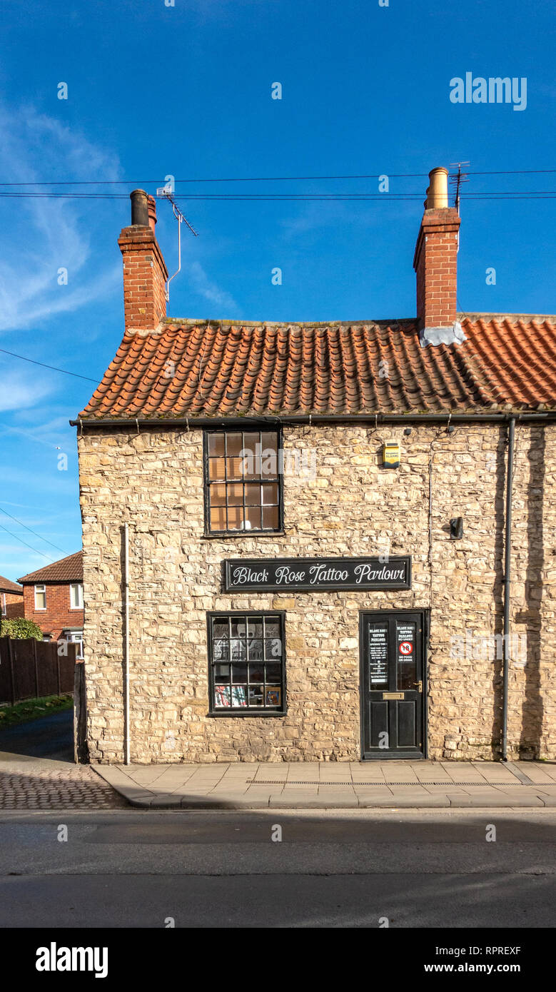 Villaggio Inglese piccola pietra costruito il negozio di fronte chiamato Black Rose Tattoo Parlor in luogo di mercato, Tickhill a Doncaster in South Yorkshire, Inghilterra Foto Stock