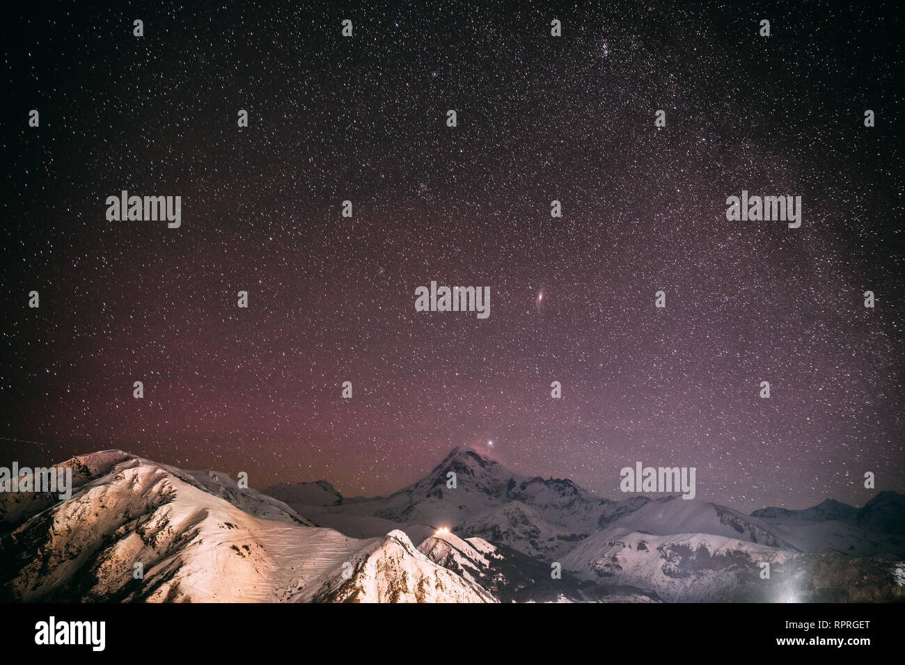 La Georgia. Notte invernale cielo stellato con incandescente stelle sulla cima del monte Kazbek coperte di neve. Bella notte georgiano Paesaggio invernale Foto Stock