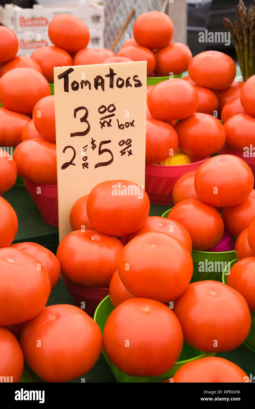 I contenitori in plastica con appena raccolto pomodori rossi - Solanum lycopersicum per la vendita in un mercato all'aperto Foto Stock