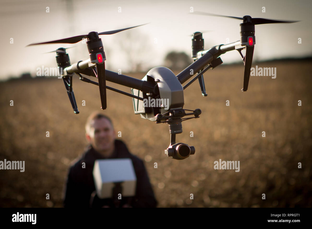 Drone quadcopter con operatore volare al di sopra del raccolto sondaggio conduttore Foto Stock
