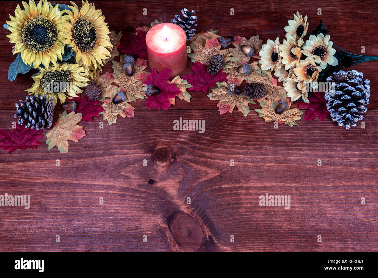 Il decor di ringraziamento con candela, smerigliato pigne, girasoli, ghiande e foglie di acero Foto Stock