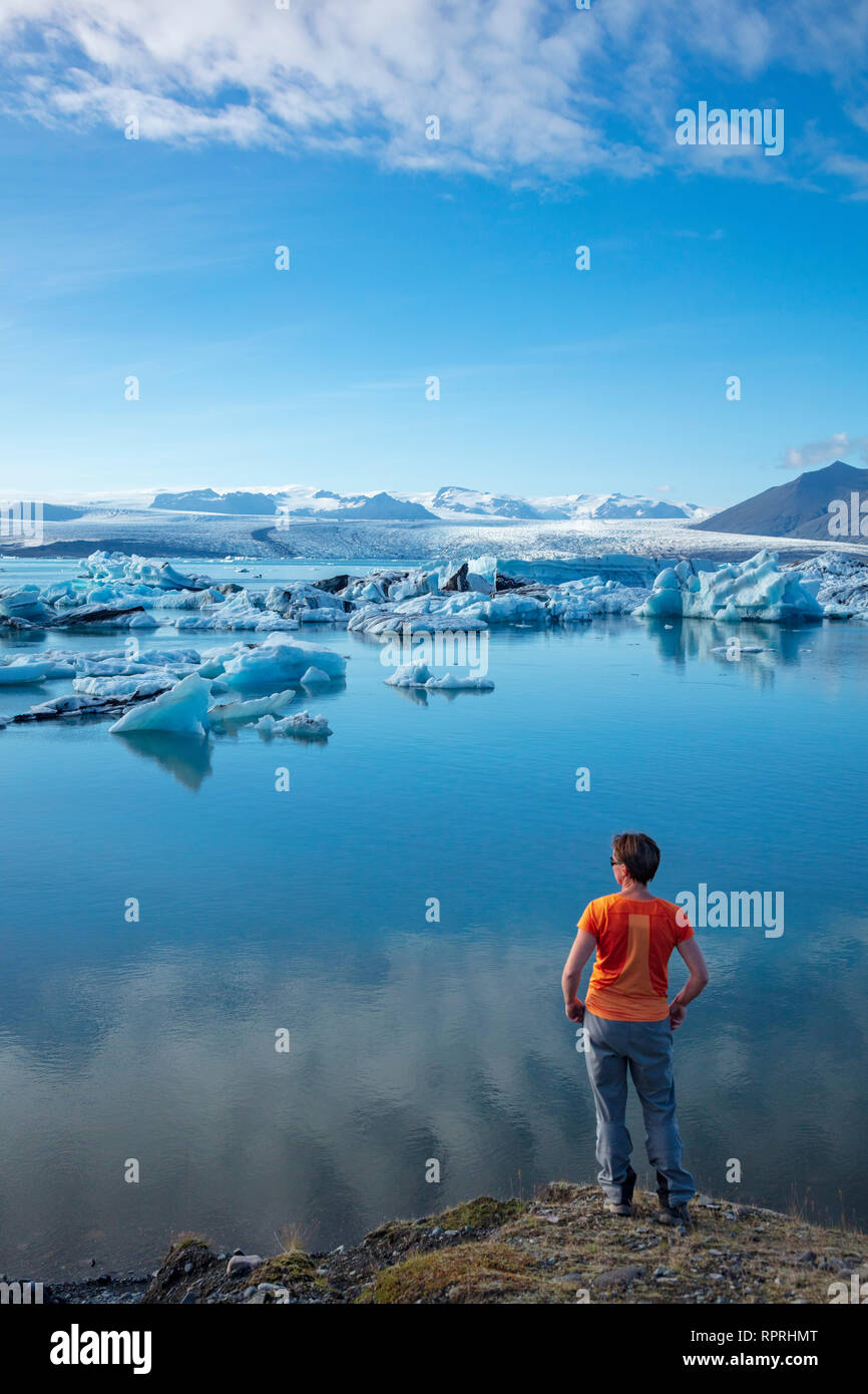 Persona sulla riva di Jokulsarlon laguna glaciale, al di sotto del ghiacciaio Vatnajokull Vatnajokull National Park, Sudhurland, sud est dell'Islanda. Foto Stock