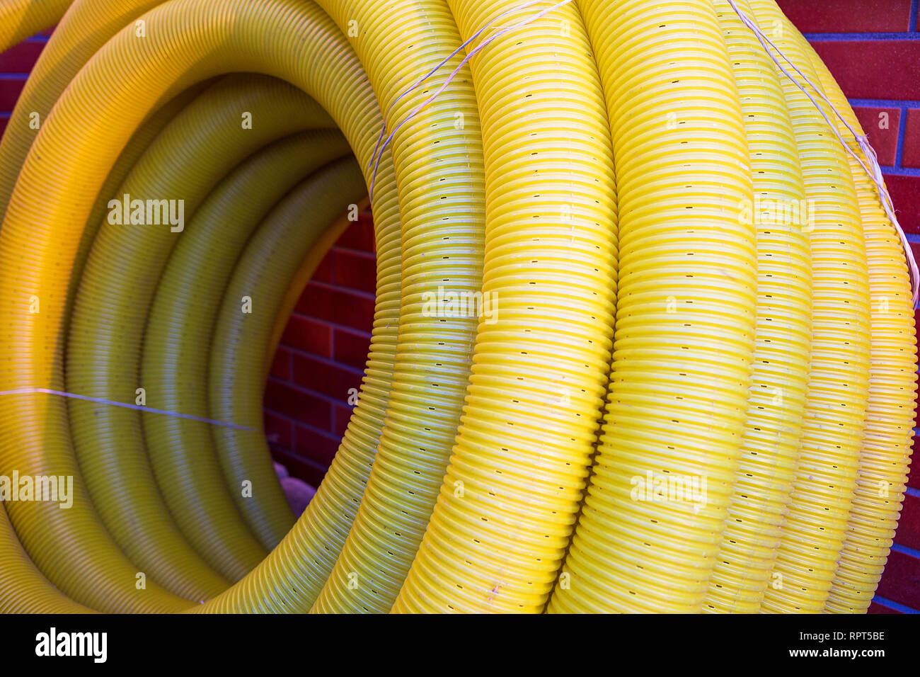 Bobina di giallo forata tubo ondulato è in attesa di essere installati come  francese del sistema di scarico Foto stock - Alamy