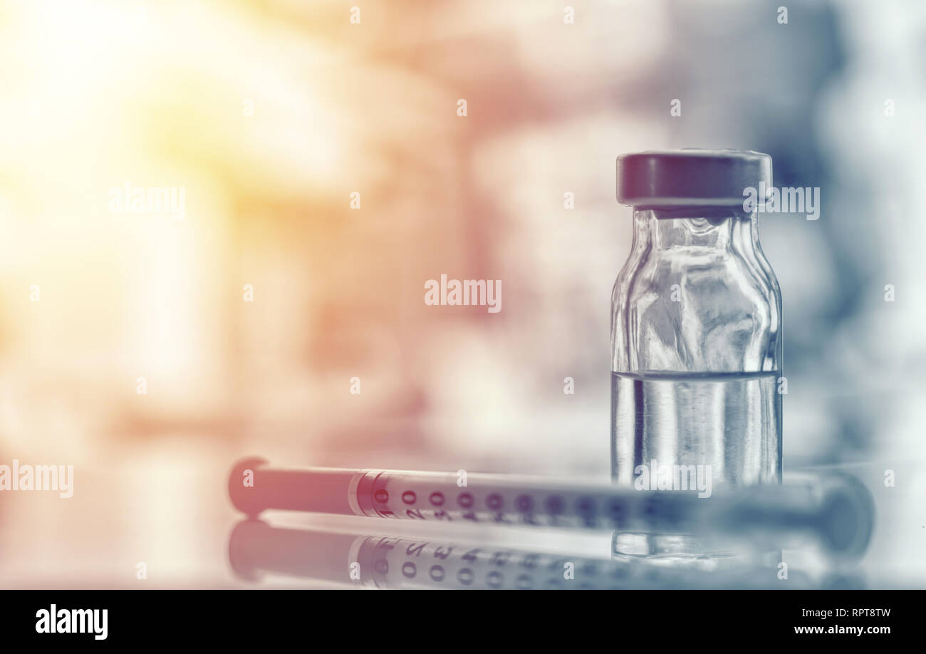 Primo piano della fiala di farmaco o influenza, il vaccino del morbillo flacone con ago e siringa per la immunizzazione su vintage sfondo medica, medicina e farmaco conc Foto Stock