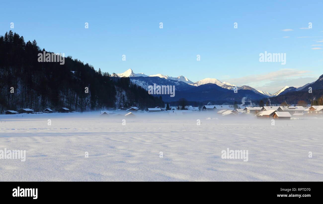 Nebbia di mattina su village a Garmisch - Partenkirchen coperte di neve. Foto Stock