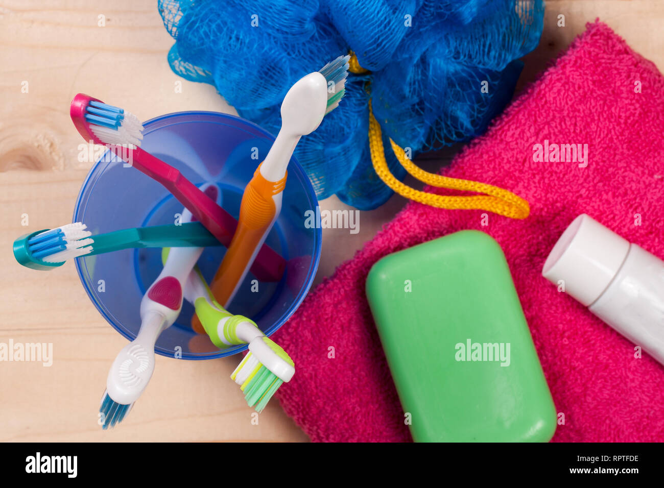 Gli spazzolini da denti, sapone, spugna e asciugamani su una tavola di legno. Prodotti igienici. La cura del corpo. Vista superiore Foto Stock