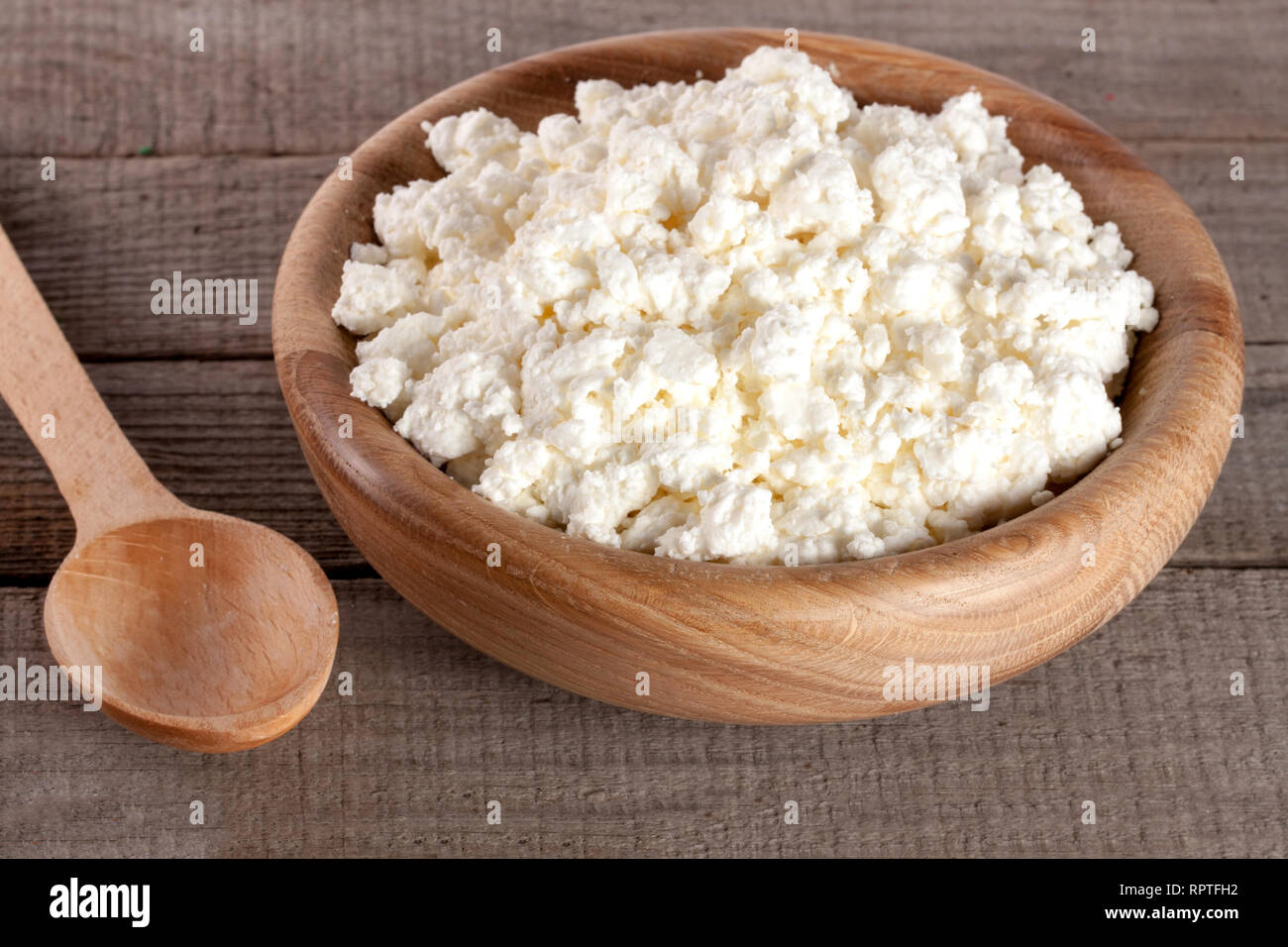 Per la ricotta in una ciotola di legno sul vecchio sfondo di legno Foto Stock