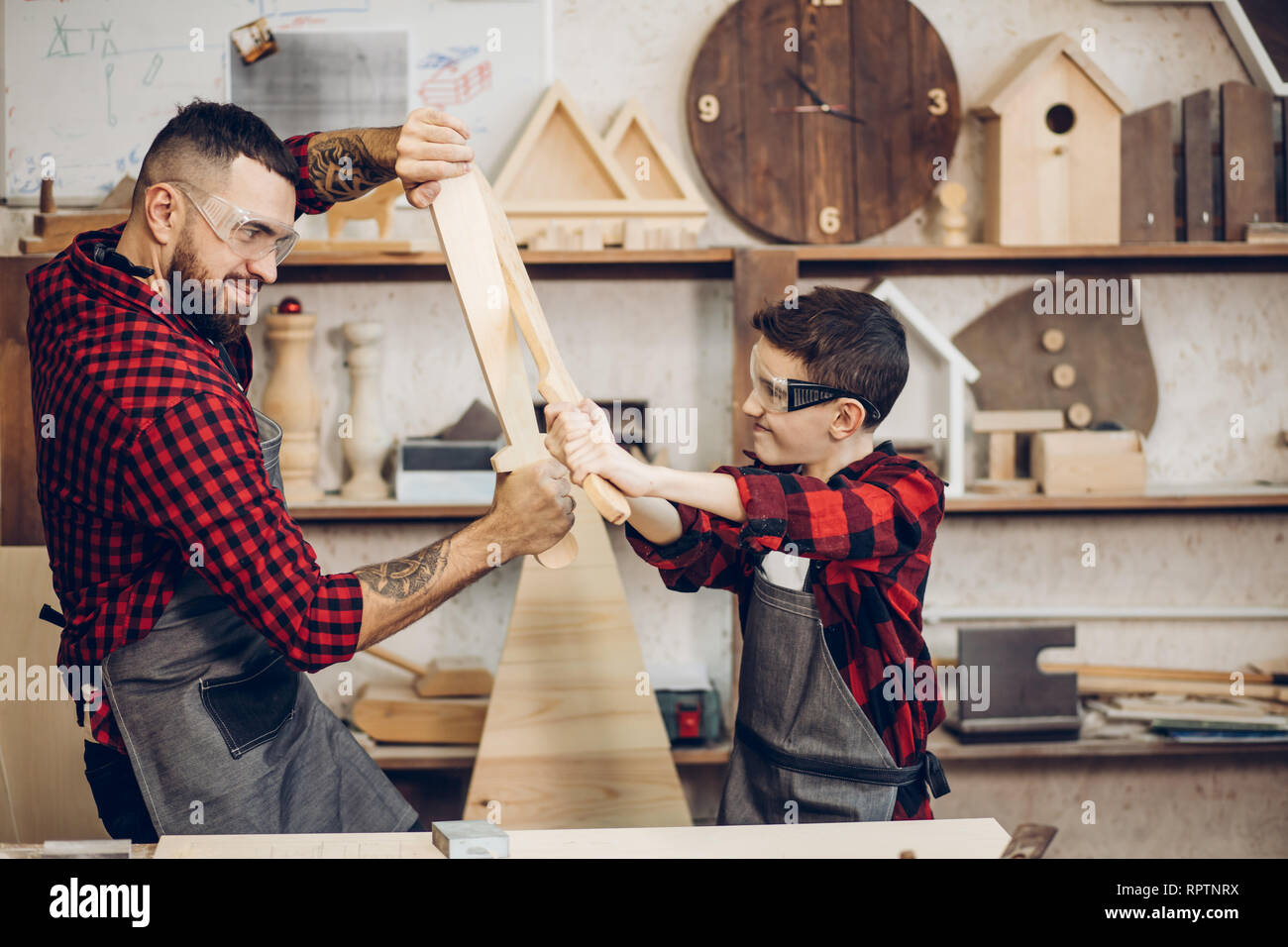 Relazioni familiari, la paternità, hobby, falegnameria, concetto di  falegnameria - padre e figlio la riproduzione di cavalieri con legno spade  DIY al workshop di falegname Foto stock - Alamy