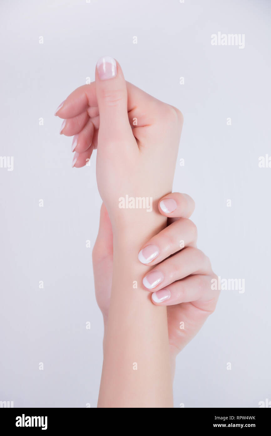 Giovane donna mani con Unghie french manicure style isolati su sfondo bianco in studio. Bellezza e chiodi concetto polacca. Close up, il fuoco selettivo Foto Stock