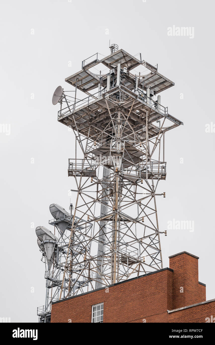 Comunicazioni a microonde o torre di telecomunicazioni seduta in cima a un grande edificio di mattoni o struttura in Montgomery, Alabama USA. Foto Stock