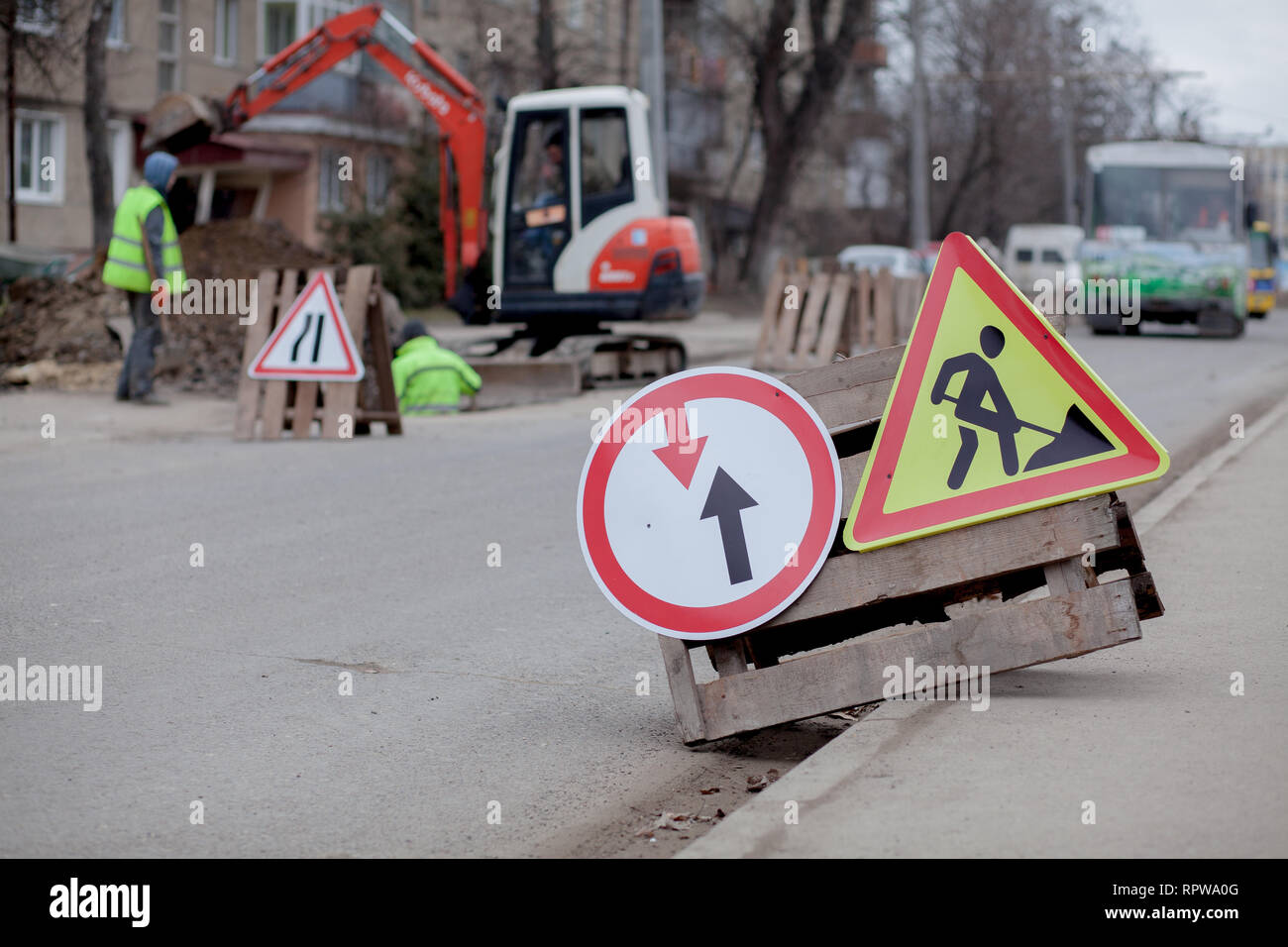 Segnaletica stradale, deviazione, riparazione su strada su strada, sfondo carrello escavatore e foro di scavo. Foto Stock