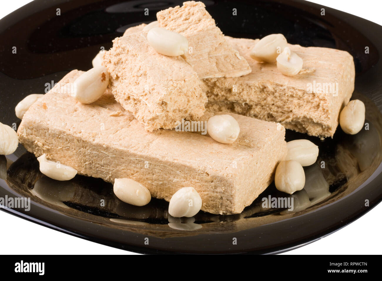 Peanut halva su una piastra nera isolati su sfondo bianco Foto Stock