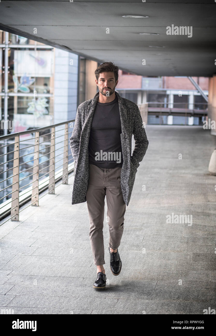 Un attraente uomo in ambiente cittadino indossa cardigan Foto Stock
