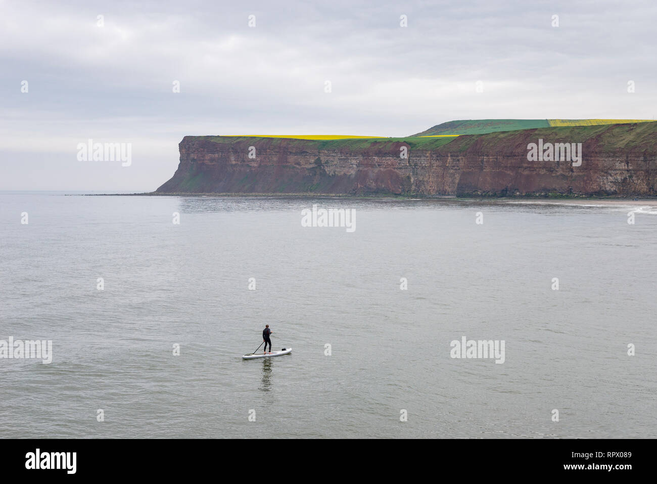 Uomo su una racchetta in pensione il mare a cambs, North Yorkshire, Inghilterra. Foto Stock