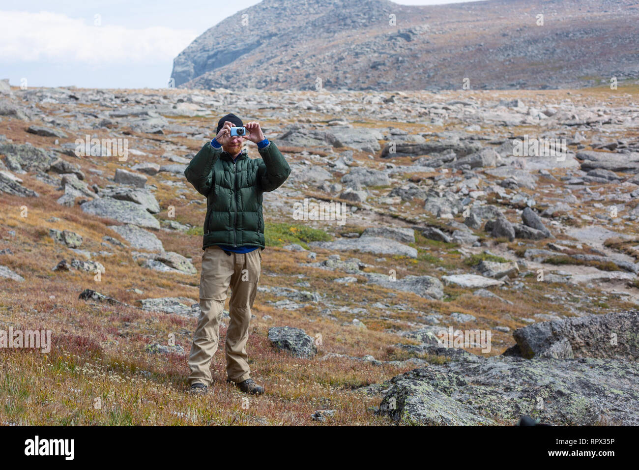 Uomo in piedi nelle montagne di scattare una foto, Stati Uniti Foto Stock