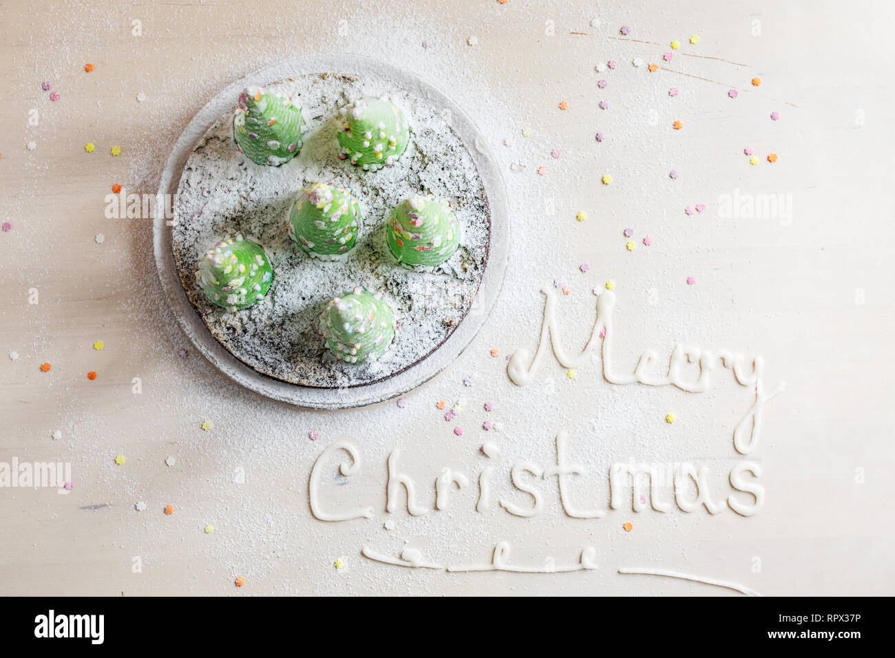 Torta decorata con alberi di Natale e auguri di Buon Natale e scritto di glassa Foto Stock