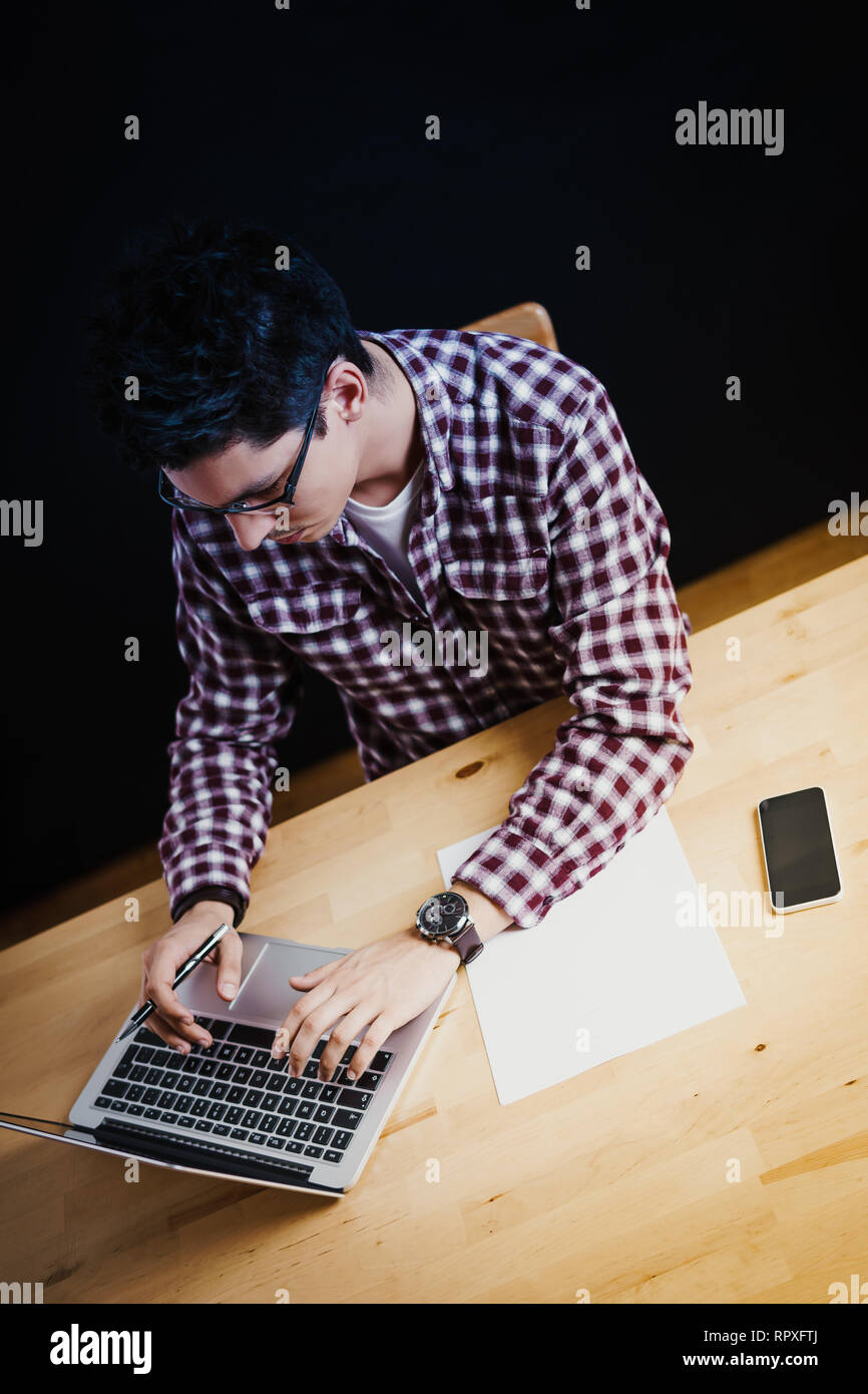 Programmatore in lavoro di ufficio sul computer su una scrivania in legno Foto Stock