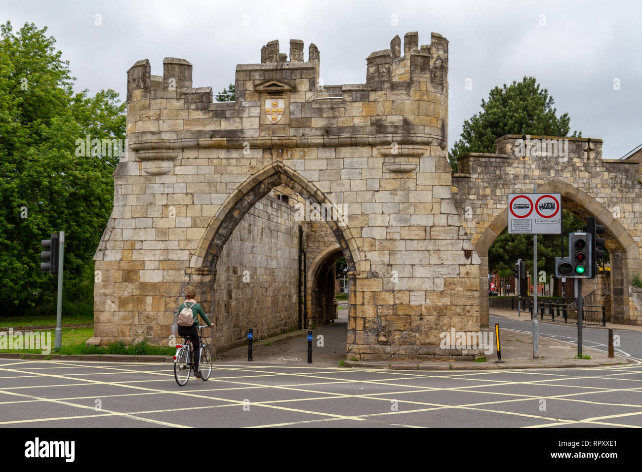 Un ciclista entrando Walmgate Bar (vista da fuori le mura), parte delle mura della città nella città di York, UK. Foto Stock