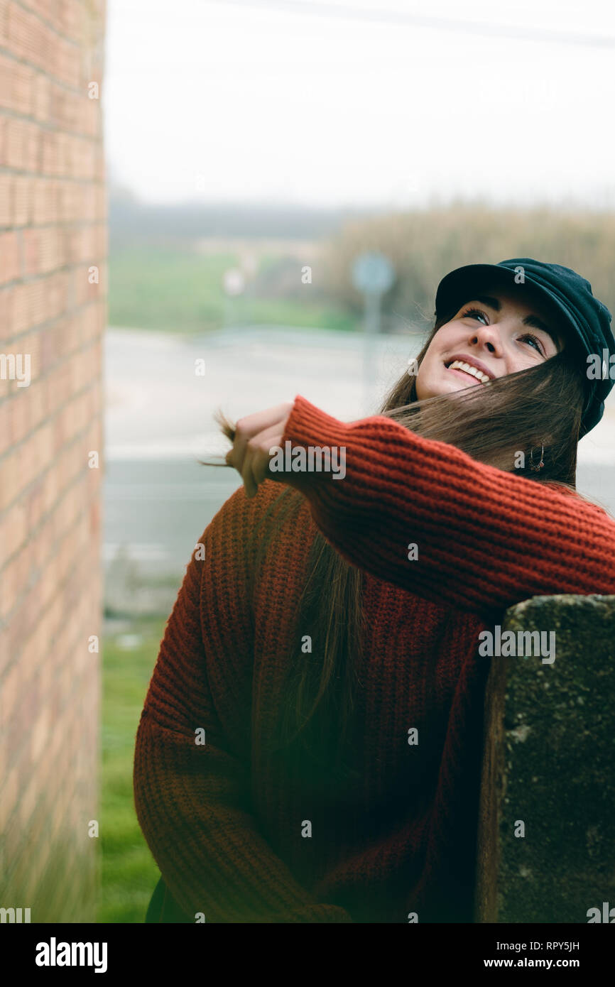Attraente donna con cappello a ridere e sorridente ritratto in una scena rurale Foto Stock