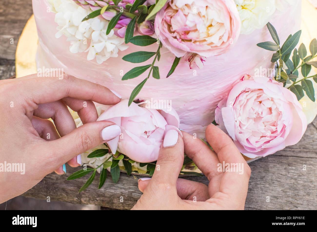 Processo di decorazioni di big pink torta nuziale con fiori Foto Stock