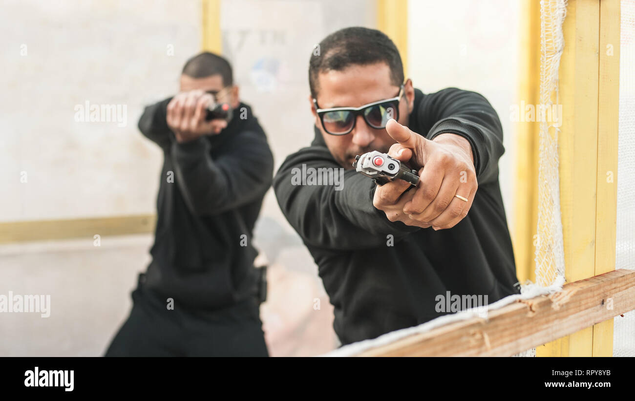 Pistola di combattimento addestramento al tiro da dietro e intorno al coperchio o barricade. Advanced combattimenti tattici corsi di tiro sul poligono di tiro Foto Stock