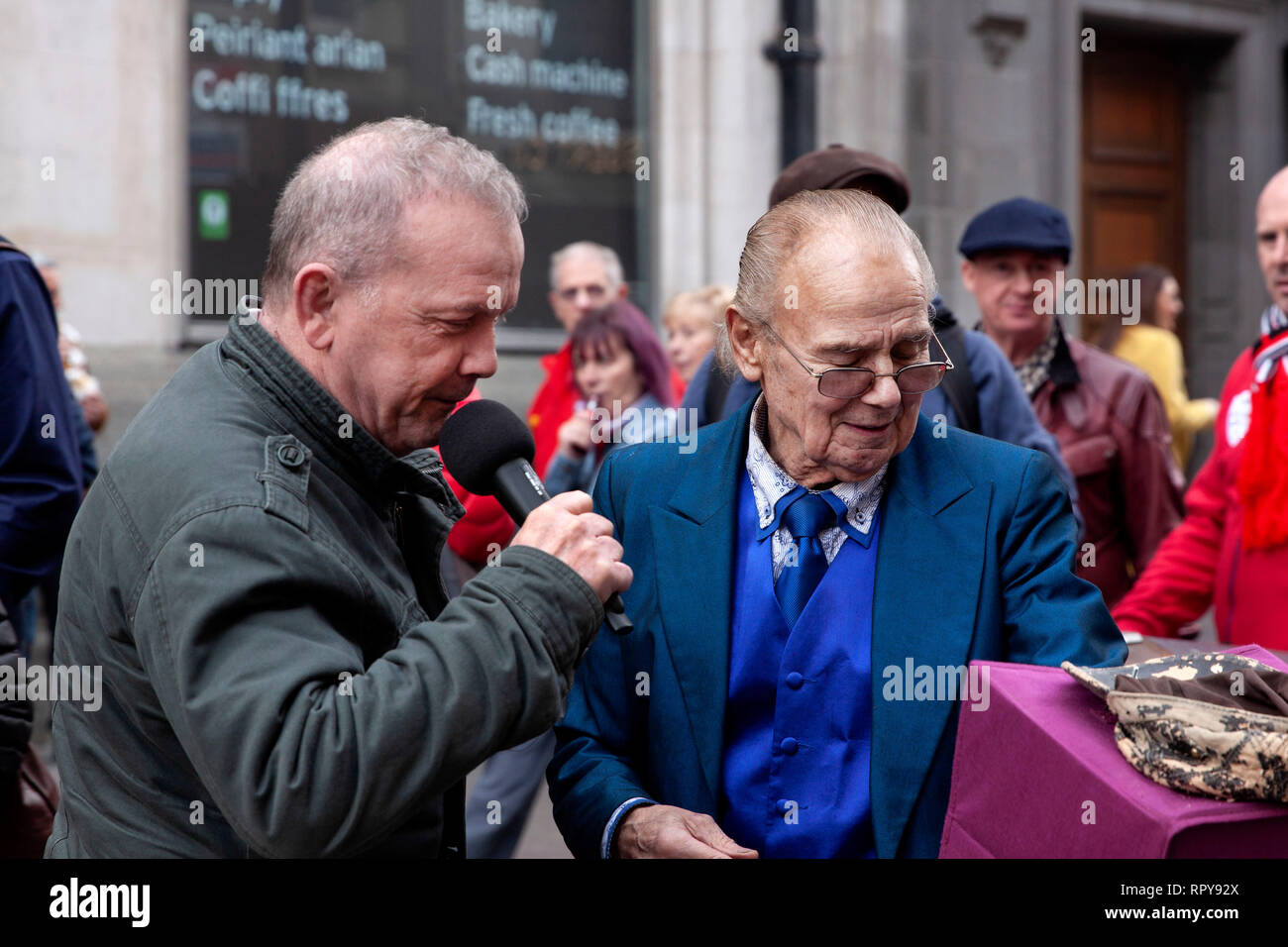 CARDIFF, Regno Unito. Il 23 febbraio 2019. Rugby gallese fan cantando con un esecutore di strada nel centro di Cardiff prima dell'Inghilterra e Galles sei N Foto Stock
