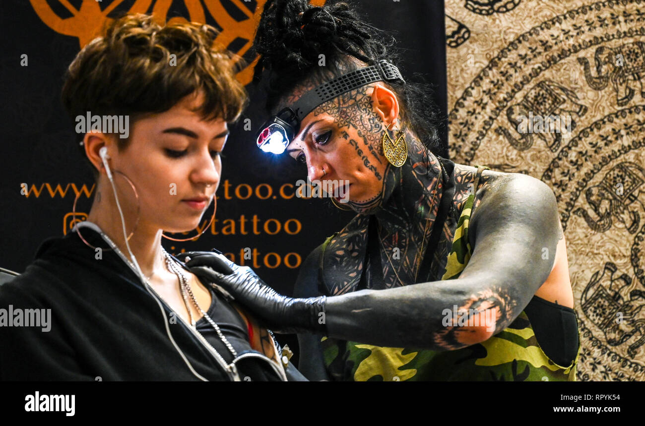 Brighton Regno Unito 23 Febbraio 2019 - divinità tattoo lavorando al dodicesimo annuale di Brighton Tattoo Convention tenutasi nel centro di Brighton per tutto il weekend con oltre 300 world class tattooists prendendo parte Credito: Simon Dack/Alamy Live News Foto Stock