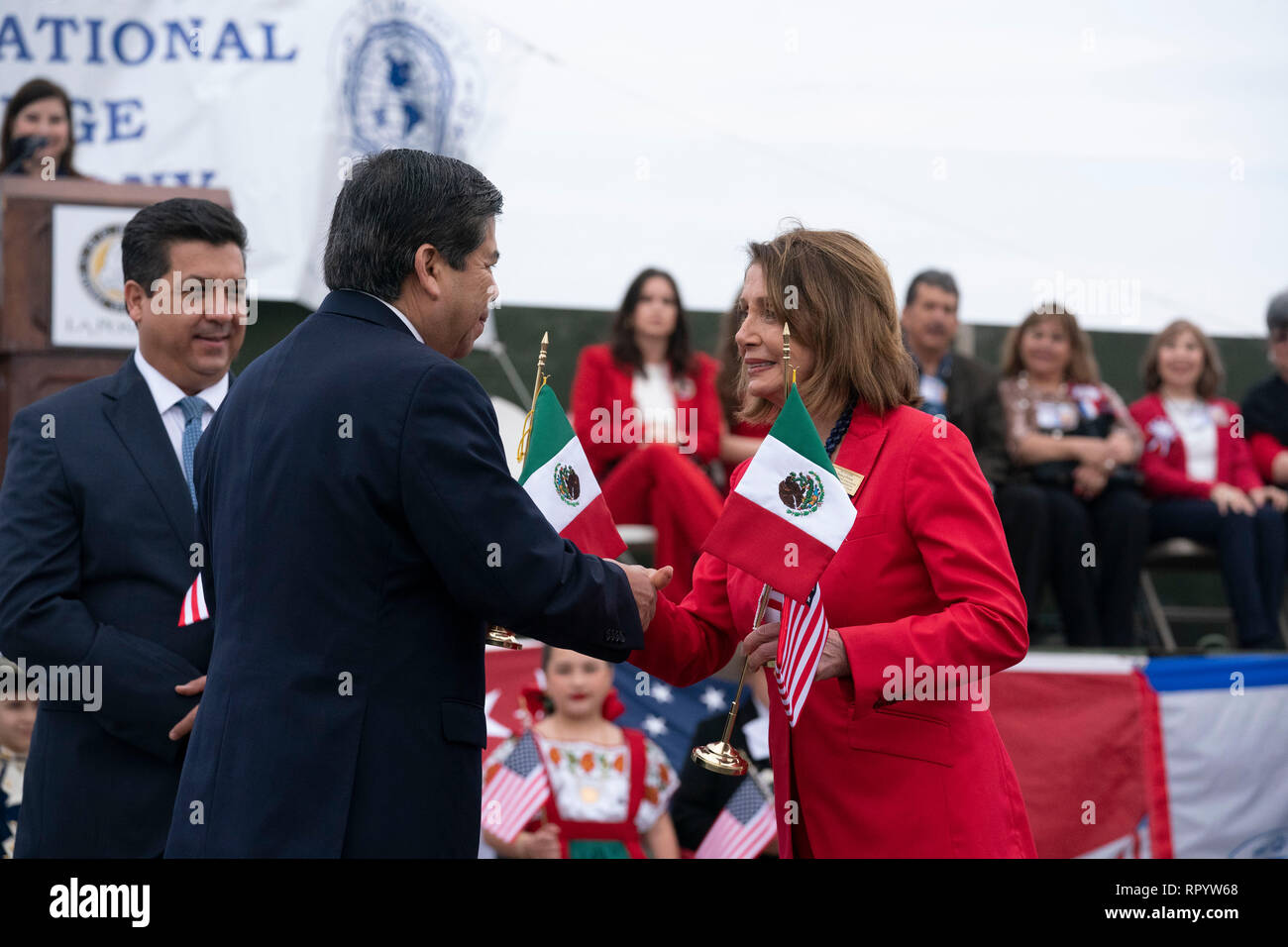 Camera dei rappresentanti degli Stati Uniti Speaker Nancy Pelosi, saluta Istituto Nazionale di Migrazione commissario Dr. Tonatiuh Guillen Lopez come Francisco Javier Garcia Cabeza de Vaca (cravatta blu), il governatore dello stato messicano di Tamaulipas, guarda su durante il abrazo (amicizia) cerimonia sulla Juarez Lincoln ponte internazionale tra Laredo, Texas, e Nuevo Laredo in Tamaulipas come parte di Laredo annuali di Washington la celebrazione di compleanno. Foto Stock