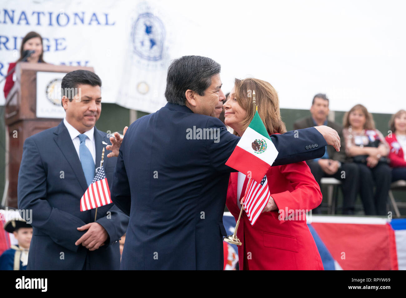 Camera dei rappresentanti degli Stati Uniti Speaker Nancy Pelosi, saluta Istituto Nazionale di Migrazione commissario Dr. Tonatiuh Guillen Lopez come Francisco Javier Garcia Cabeza de Vaca (cravatta blu), il governatore dello stato messicano di Tamaulipas, guarda su durante il abrazo (amicizia) cerimonia sulla Juarez Lincoln ponte internazionale tra Laredo, Texas, e Nuevo Laredo in Tamaulipas come parte di Laredo annuali di Washington la celebrazione di compleanno. Foto Stock