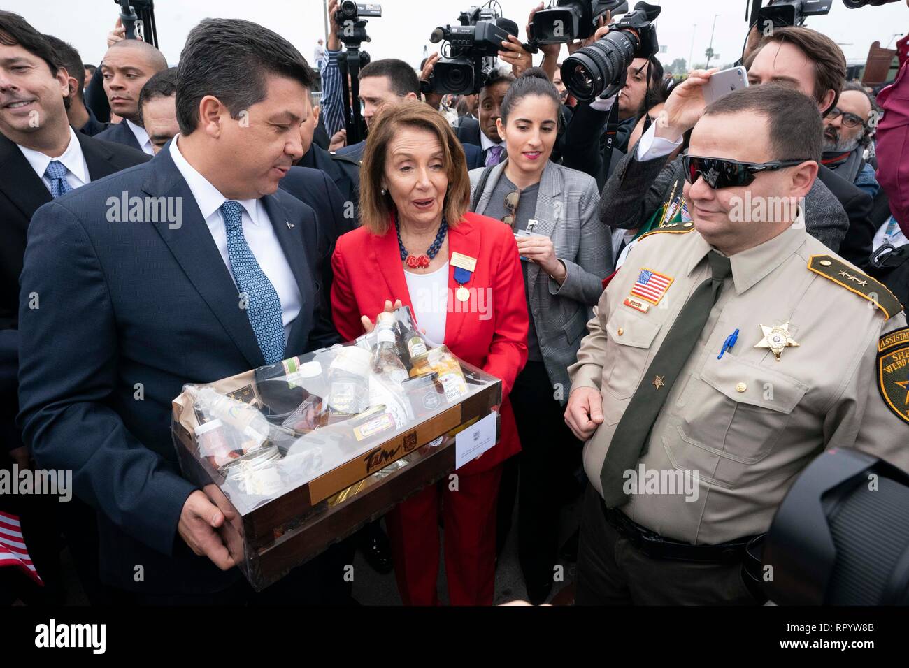 Camera dei rappresentanti degli Stati Uniti Presidente della Camera Nancy Pelosi riceve un regalo da Francisco Javier Garcia Cabez de Vaca, governatore dello stato messicano di Tamaulipas, in Abrazo cerimonia al confine Texas-Mexico sul Laredo ponte internazionale messicano con il governatore Francisco Javier Garcia Cabeza de Vaca (sinistra) durante la cerimonia abrazo di Laredo annuali di Washington la celebrazione di compleanno. Foto Stock