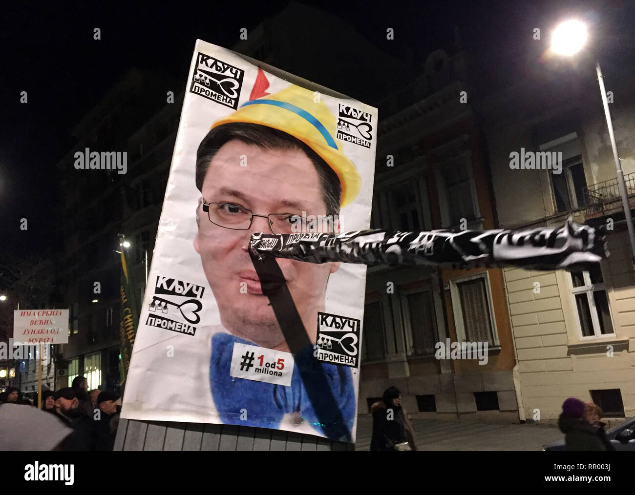 Belgrad, Serbia. Il 23 febbraio, 2019. Manifestanti tenere un poster del presidente Alexander Vucic con un lungo naso di Pinocchio durante una manifestazione di protesta contro il Presidente Vucic governo. Per il dodicesimo sabato consecutivi, i manifestanti contro il Presidente Vucic ha preso per le strade. Credito: Boris Babic/dpa/Alamy Live News Foto Stock