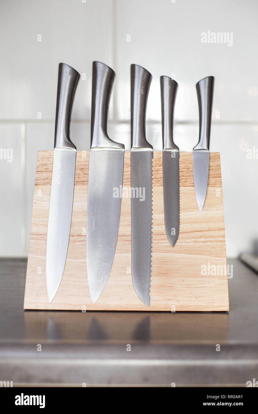 I coltelli con magnete di blocco di legno sul bancone della cucina, design  moderno Foto stock - Alamy